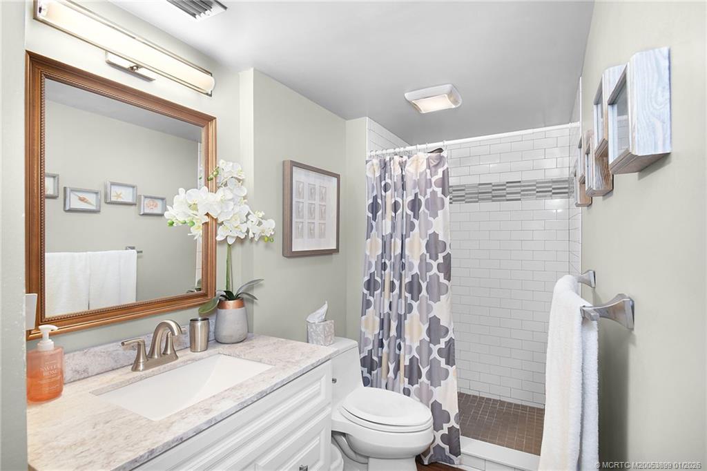 5403 Southeast Miles Grant Road, Unit H111 Stuart, FL 34997 - Photo 25 of 57 a bathroom with a granite countertop sink toilet and shower