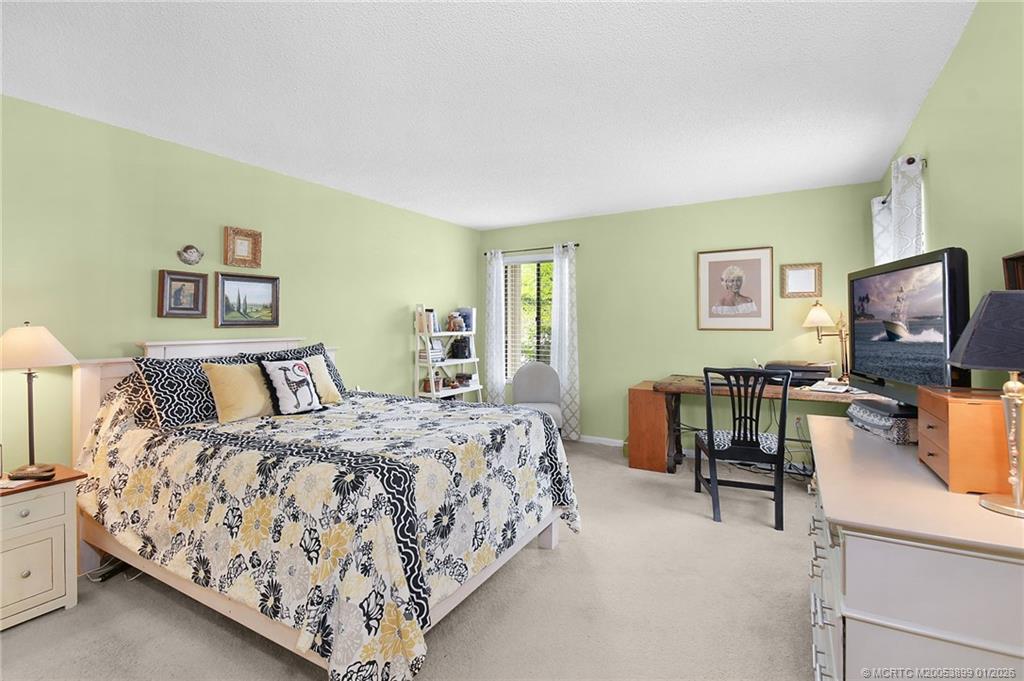 5403 Southeast Miles Grant Road, Unit H111 Stuart, FL 34997 - Photo 26 of 57 a bedroom with a bed and a flat screen tv