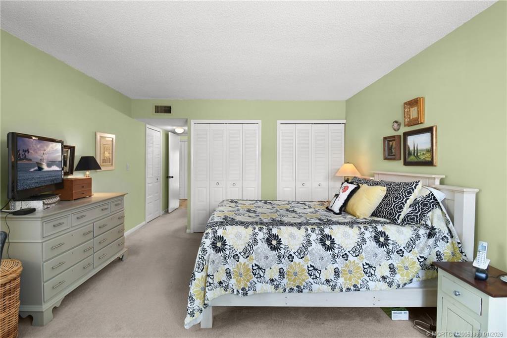 5403 Southeast Miles Grant Road, Unit H111 Stuart, FL 34997 - Photo 27 of 57 a bedroom with a bed and a flat screen television