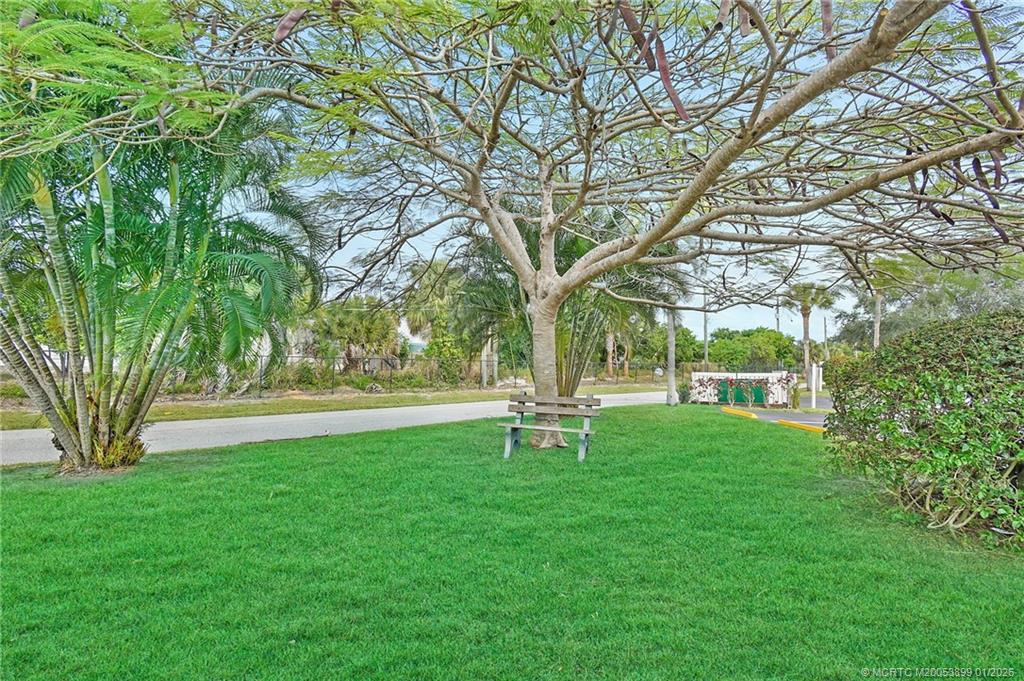 5403 Southeast Miles Grant Road, Unit H111 Stuart, FL 34997 - Photo 35 of 57 a view of a park with a bench and trees