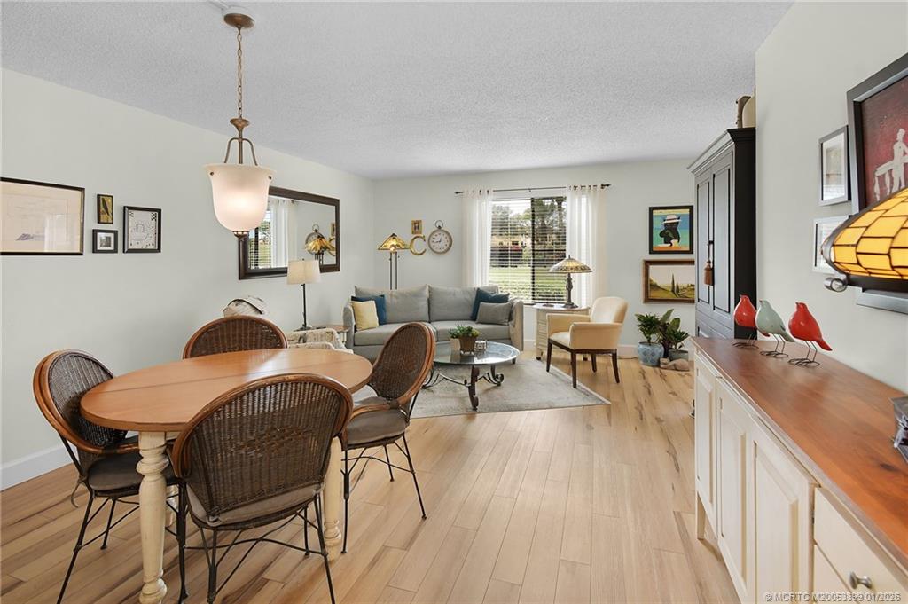 5403 Southeast Miles Grant Road, Unit H111 Stuart, FL 34997 - Photo 7 of 57 a living room with furniture a dining table and a large window