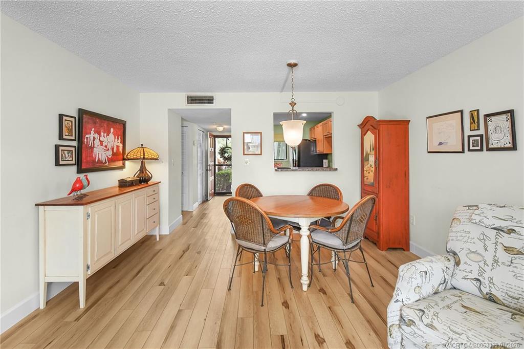 5403 Southeast Miles Grant Road, Unit H111 Stuart, FL 34997 - Photo 9 of 57 a dining room with furniture and wooden floor