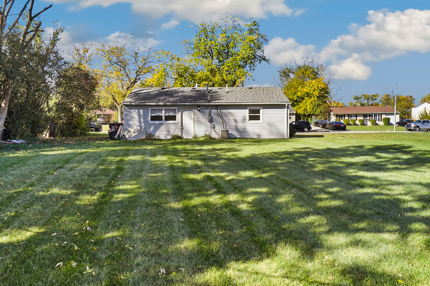 1941 Cambridge Street Chicago Heights, IL 60411 - Photo 15 of 19 a view of a house with a big yard and large trees