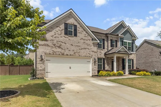 a front view of a house with a yard and garage