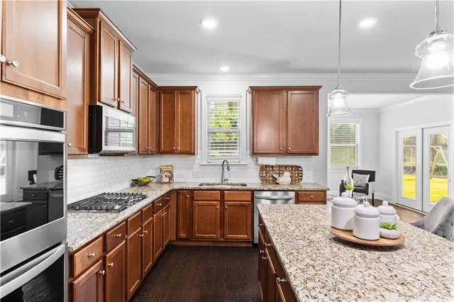 a kitchen with stainless steel appliances granite countertop a sink stove and cabinets