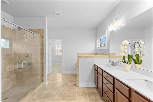 a bathroom with a sink mirror and shower