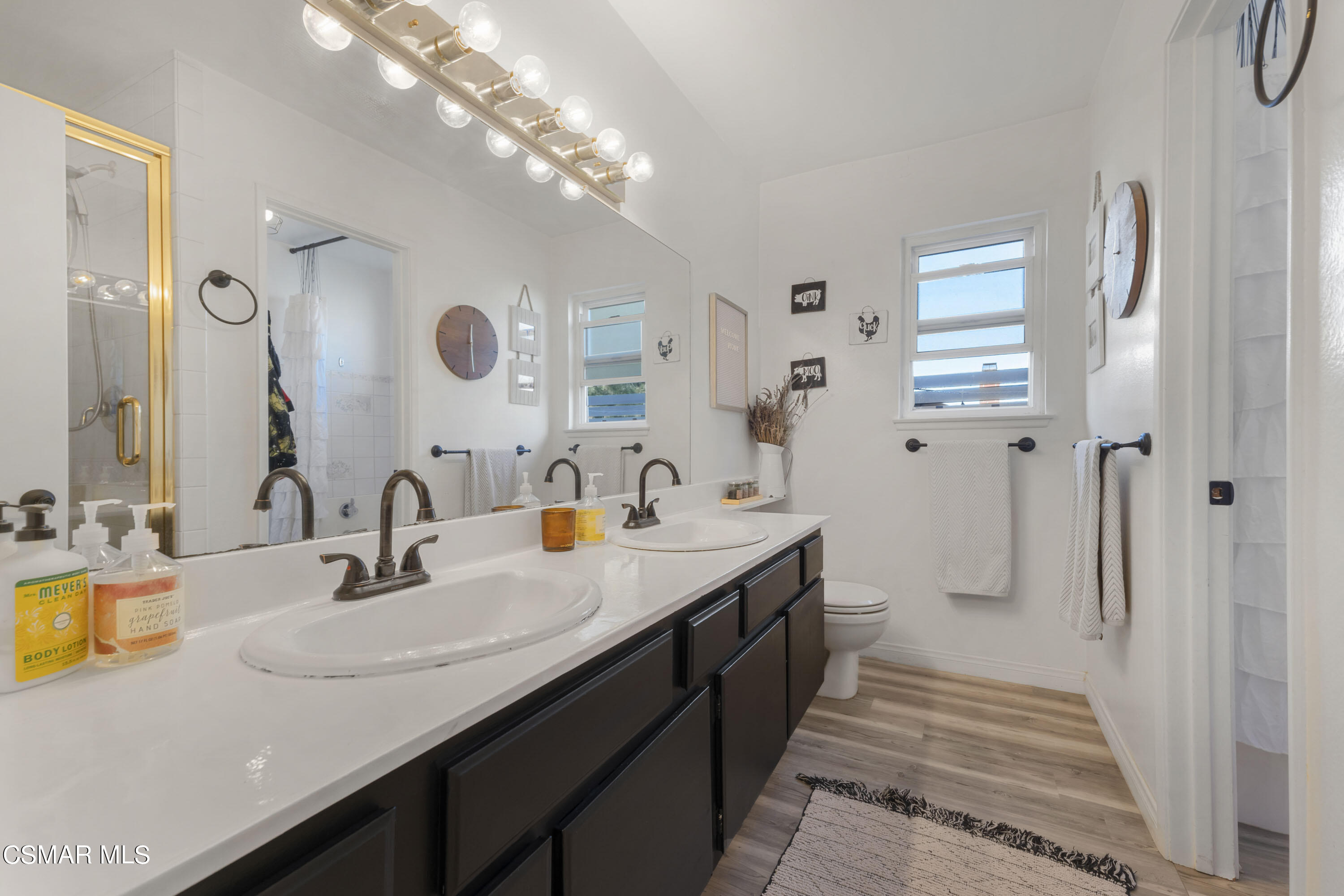 1065 Rambling Road Simi Valley, CA 93065 - Photo 11 of 54 a bathroom with a double vanity sink a mirror and shower