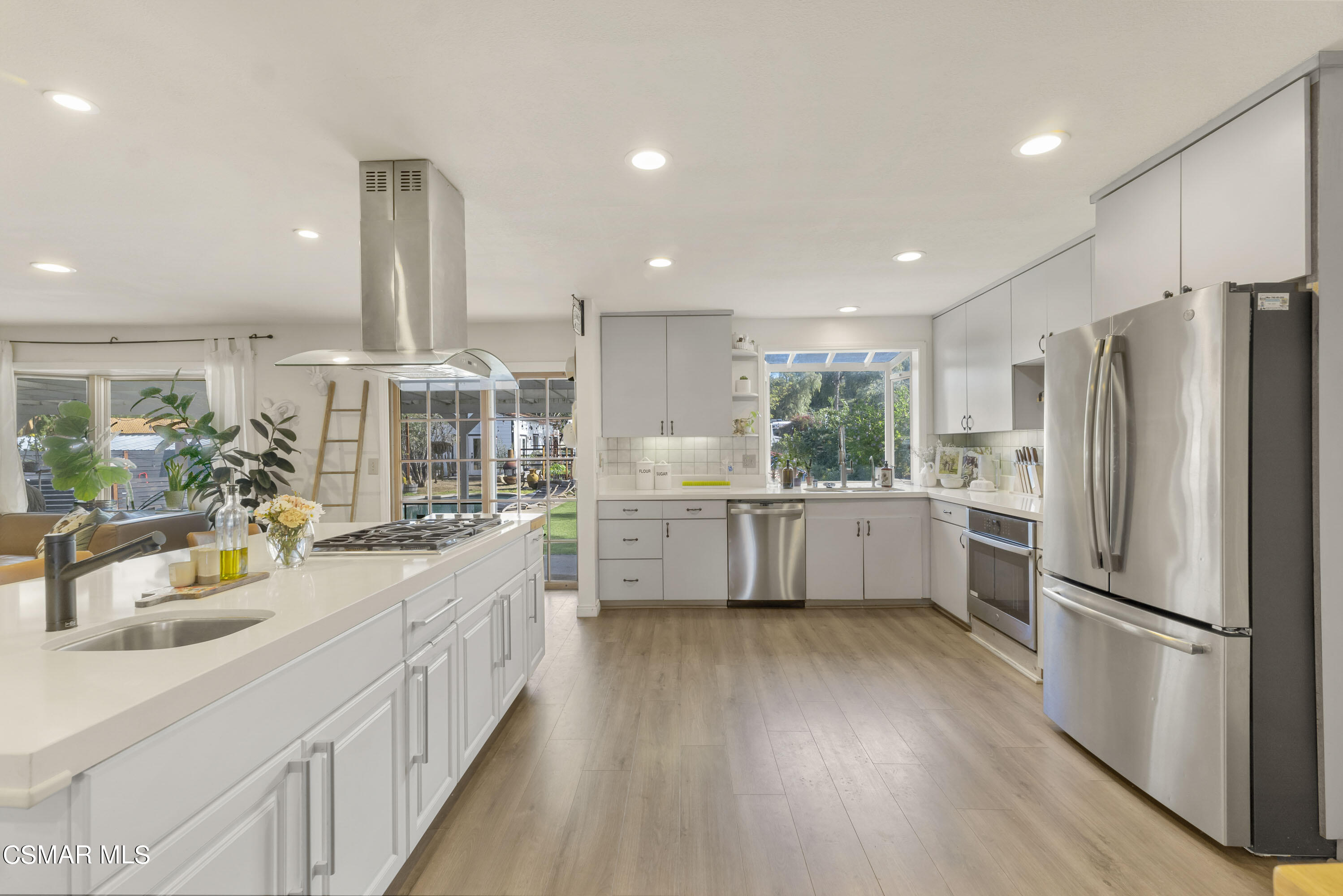 1065 Rambling Road Simi Valley, CA 93065 - Photo 7 of 54 a kitchen with stainless steel appliances a refrigerator a sink a oven and white cabinets