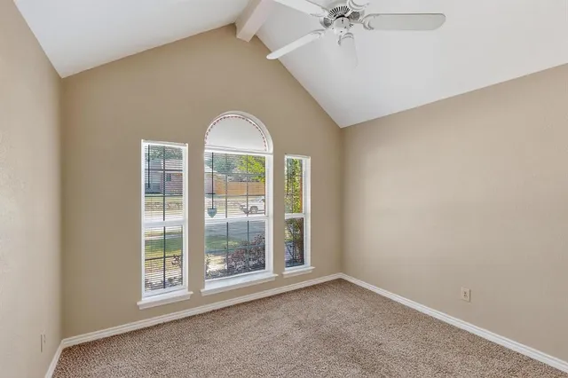 an empty room with windows and ceiling fan