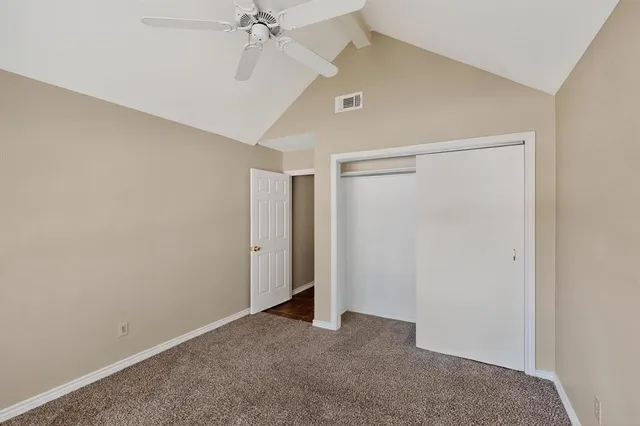 an empty room with a ceiling fan and a window