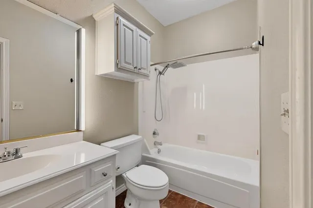 a bathroom with a sink a toilet a mirror and shower