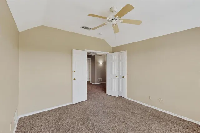 an empty room with a ceiling fan and a window