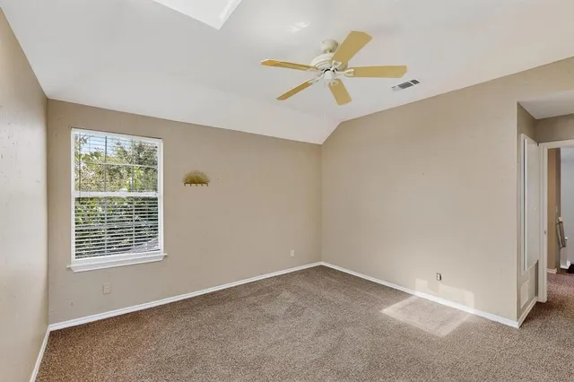 an empty room with windows and fan