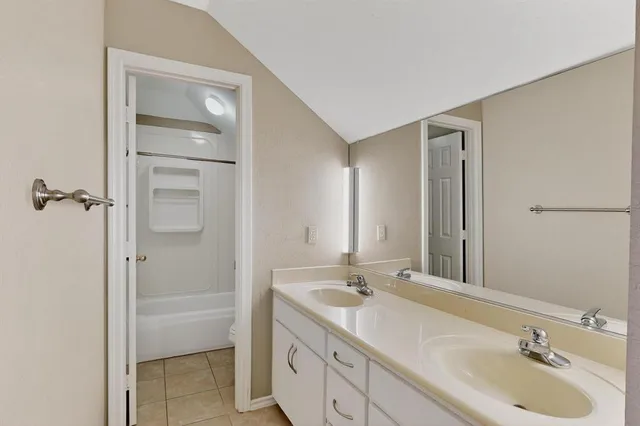 a bathroom with a double vanity sink mirror and shower
