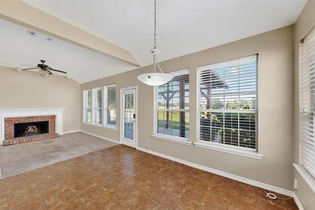 a view of livingroom with fireplace large windows and a ceiling fan