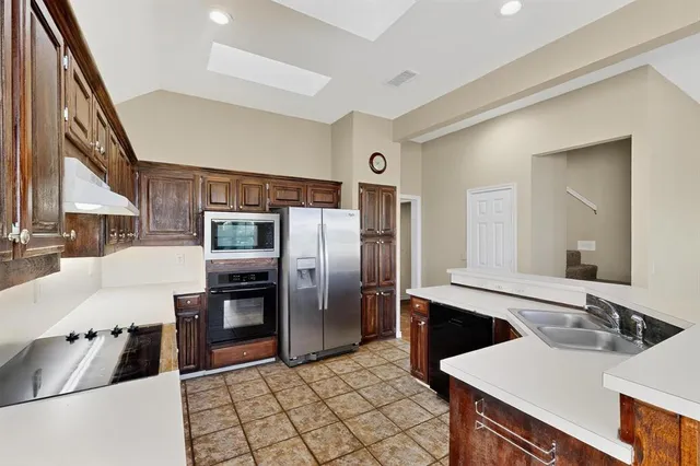 a kitchen with stainless steel appliances a sink and a refrigerator