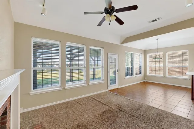 a view of a living room a fireplace and a ceiling fan
