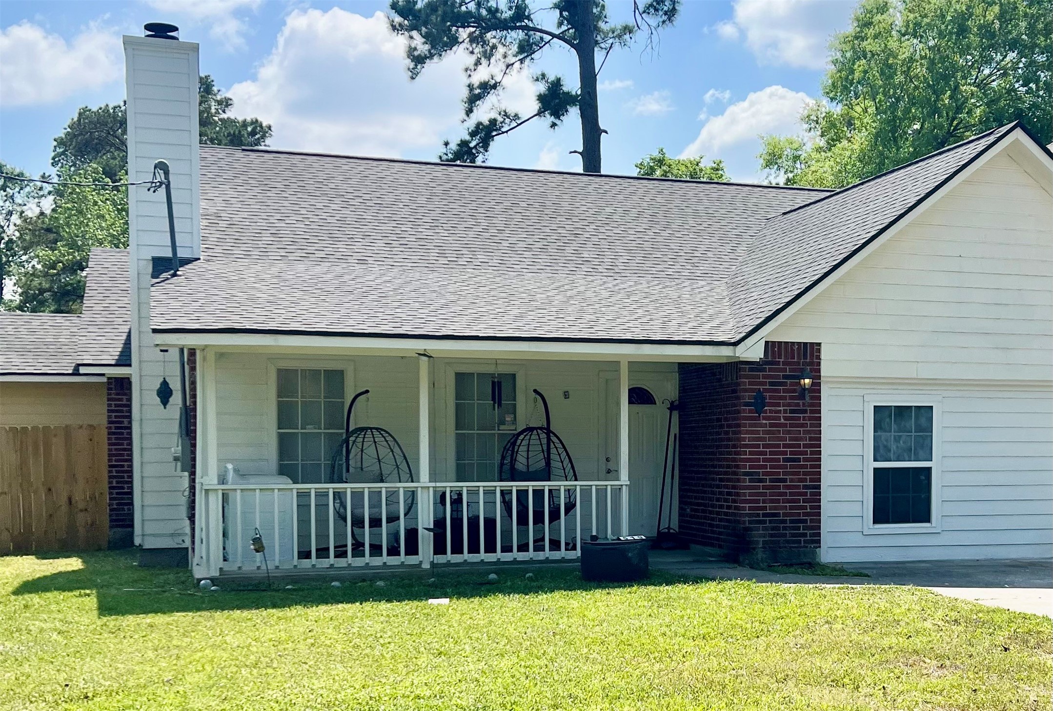 A well-kept lawn leads to an inviting covered front porch, setting a welcoming tone for this single-story Conroe home.