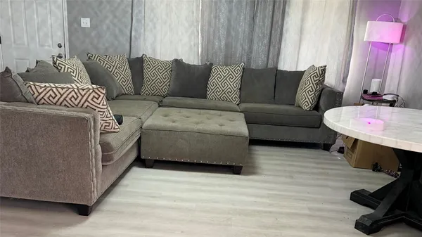 a living room with furniture and a wooden floor