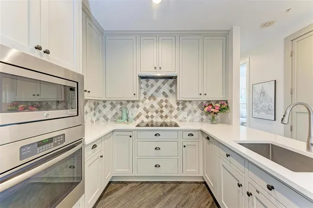 a kitchen with white cabinets and sink