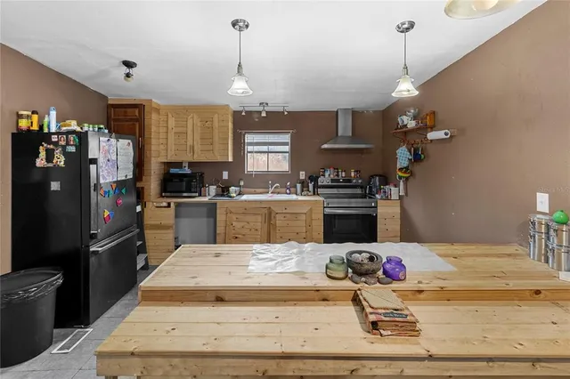 a kitchen with kitchen island white cabinets and refrigerator