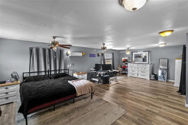 a spacious bedroom with a bed a couch and a chandelier