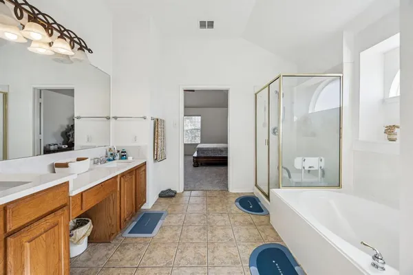 a bathroom with a tub a sink and a large mirror