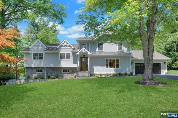 a front view of house with a garden and trees