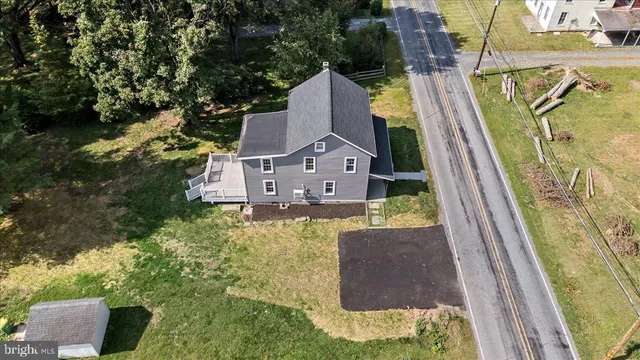 an aerial view of a house with swimming pool and large trees