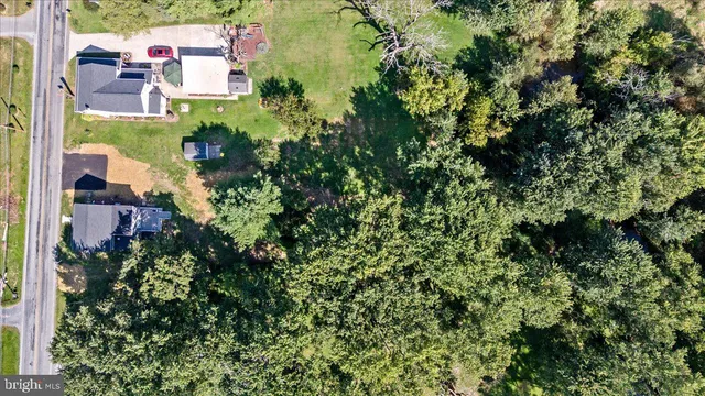 an aerial view of residential house with outdoor space and trees all around