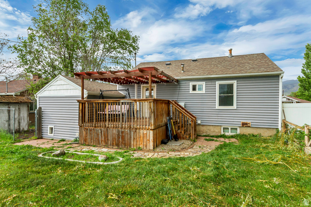 65 West 700 North Bountiful, UT 84010 - Photo 6 of 29 Rear exterior featuring a wood deck with a pergola, gray siding, a shingled roof, and a visible basement window