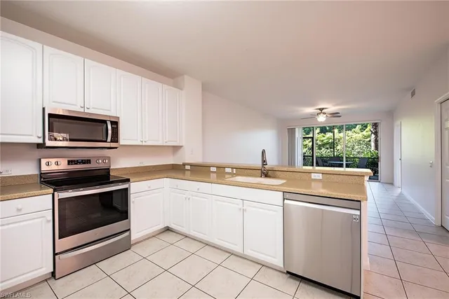 a kitchen with white cabinets sink and stainless steel appliances