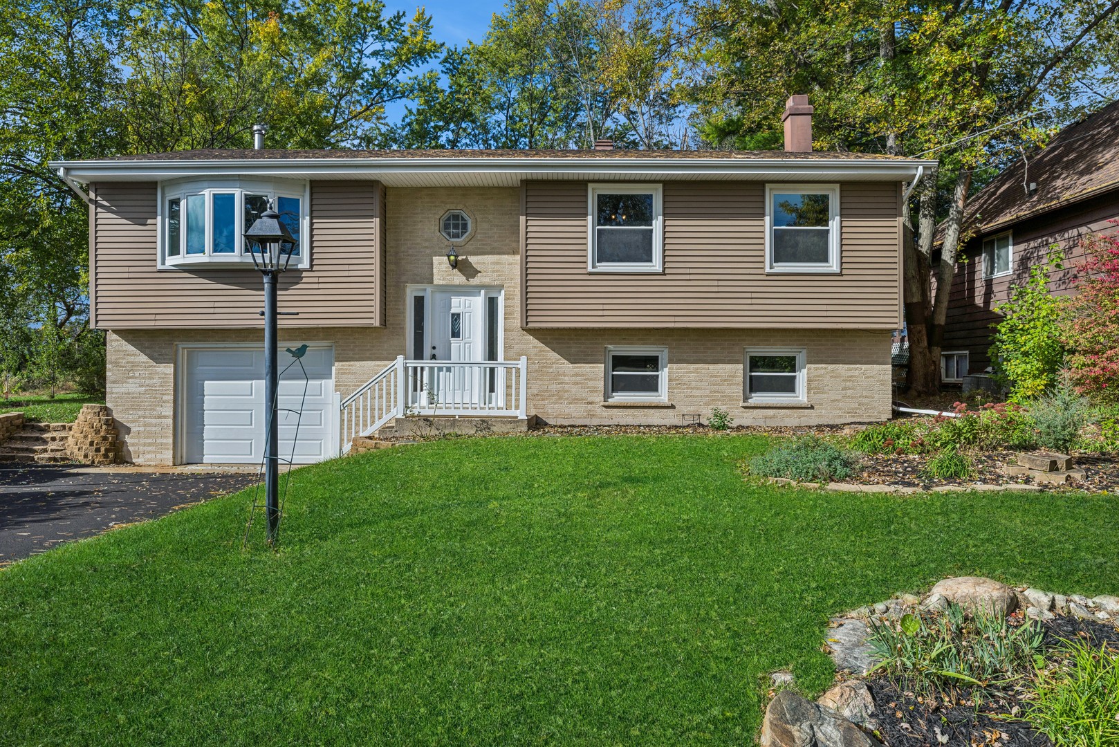 a view of a house with a yard and a large tree