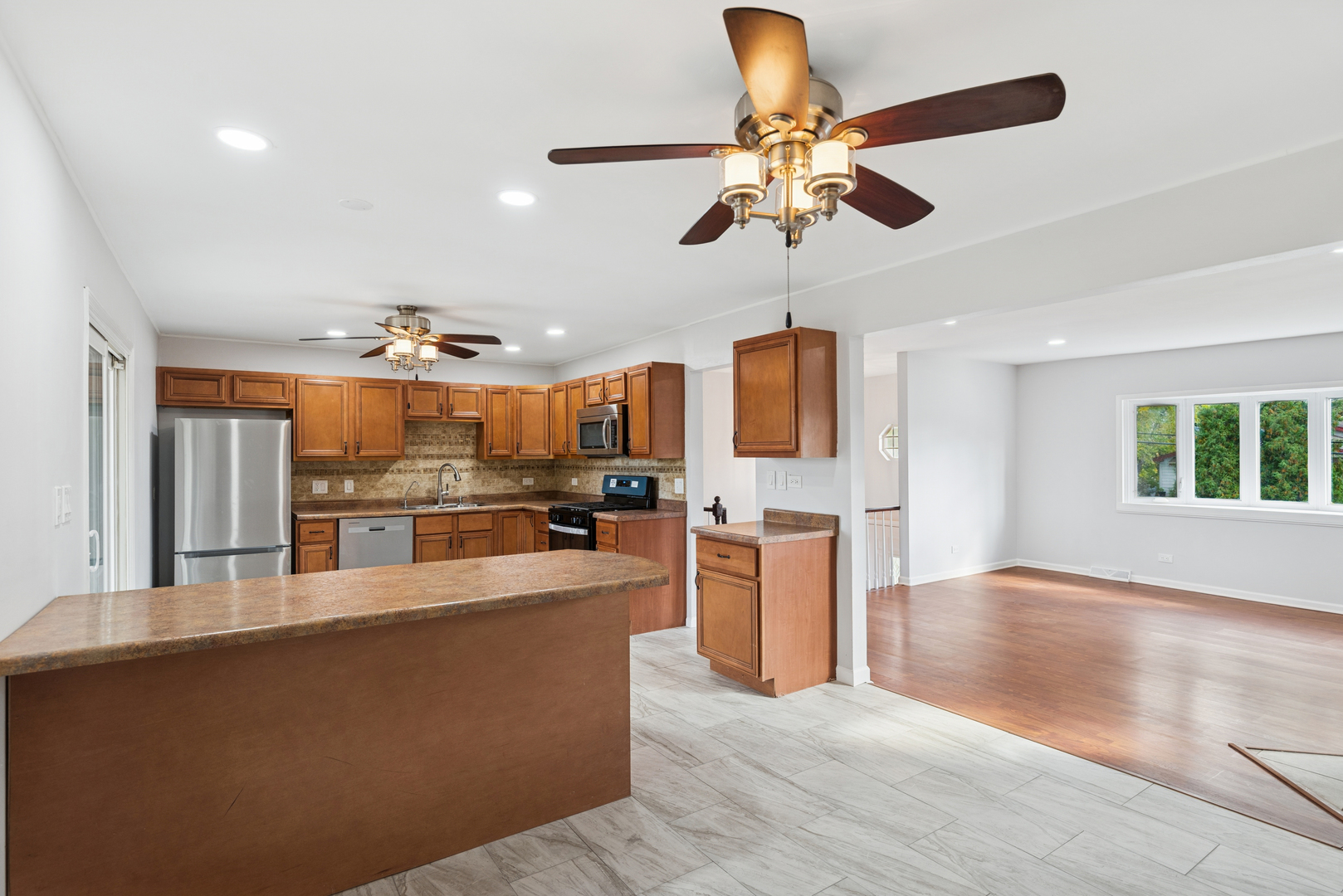 18 Greenview Road Oakwood Hills, IL 60013 - Photo 11 of 35 a living room with stainless steel appliances kitchen island granite countertop furniture a rug kitchen view and a chandelier