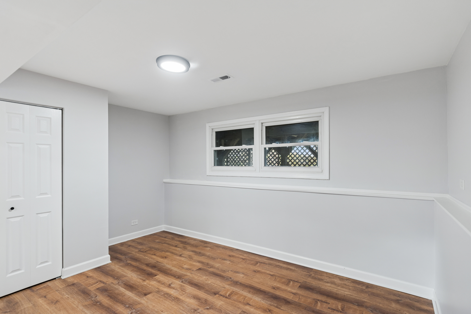 18 Greenview Road Oakwood Hills, IL 60013 - Photo 18 of 35 a view of an empty room with window and wooden floor