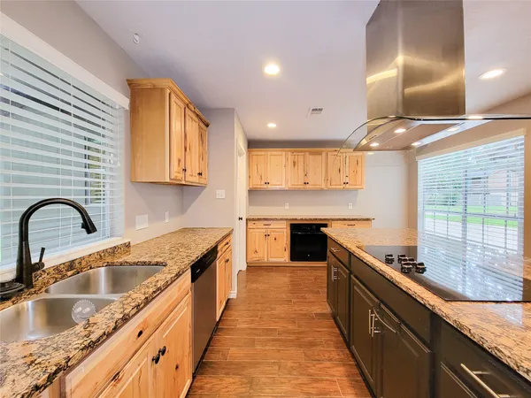 a kitchen with kitchen island granite countertop a sink stainless steel appliances and window