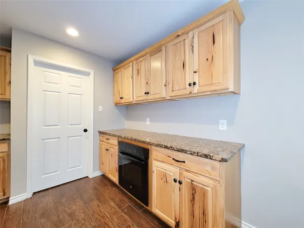a kitchen with granite countertop white cabinets and stainless steel appliances
