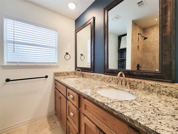 a bathroom with a granite countertop sink and a large mirror