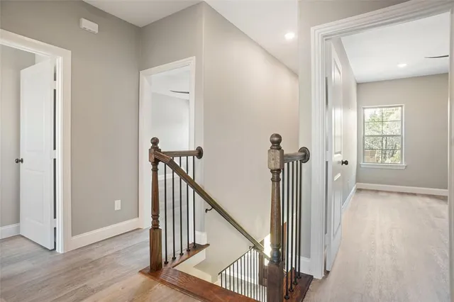 a view of a hallway with wooden floor and stairs
