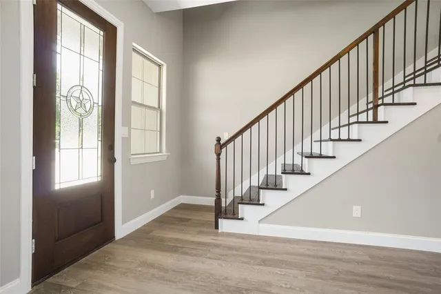 a view of an entryway with wooden floor and windows