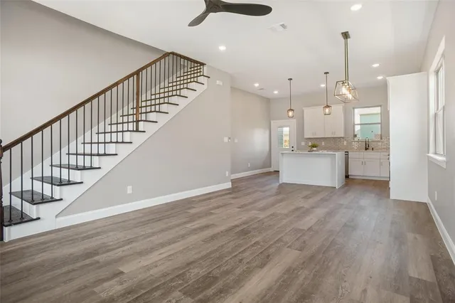 a view of a kitchen with wooden floor and stainless steel appliances