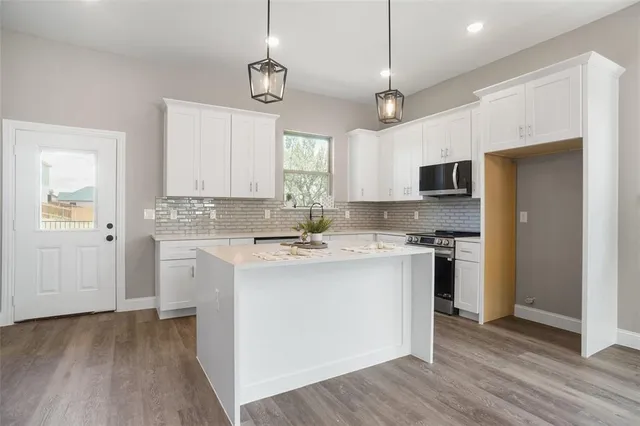 a kitchen with kitchen island a sink stainless steel appliances and window