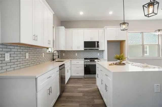a kitchen with a sink stove cabinets and refrigerator