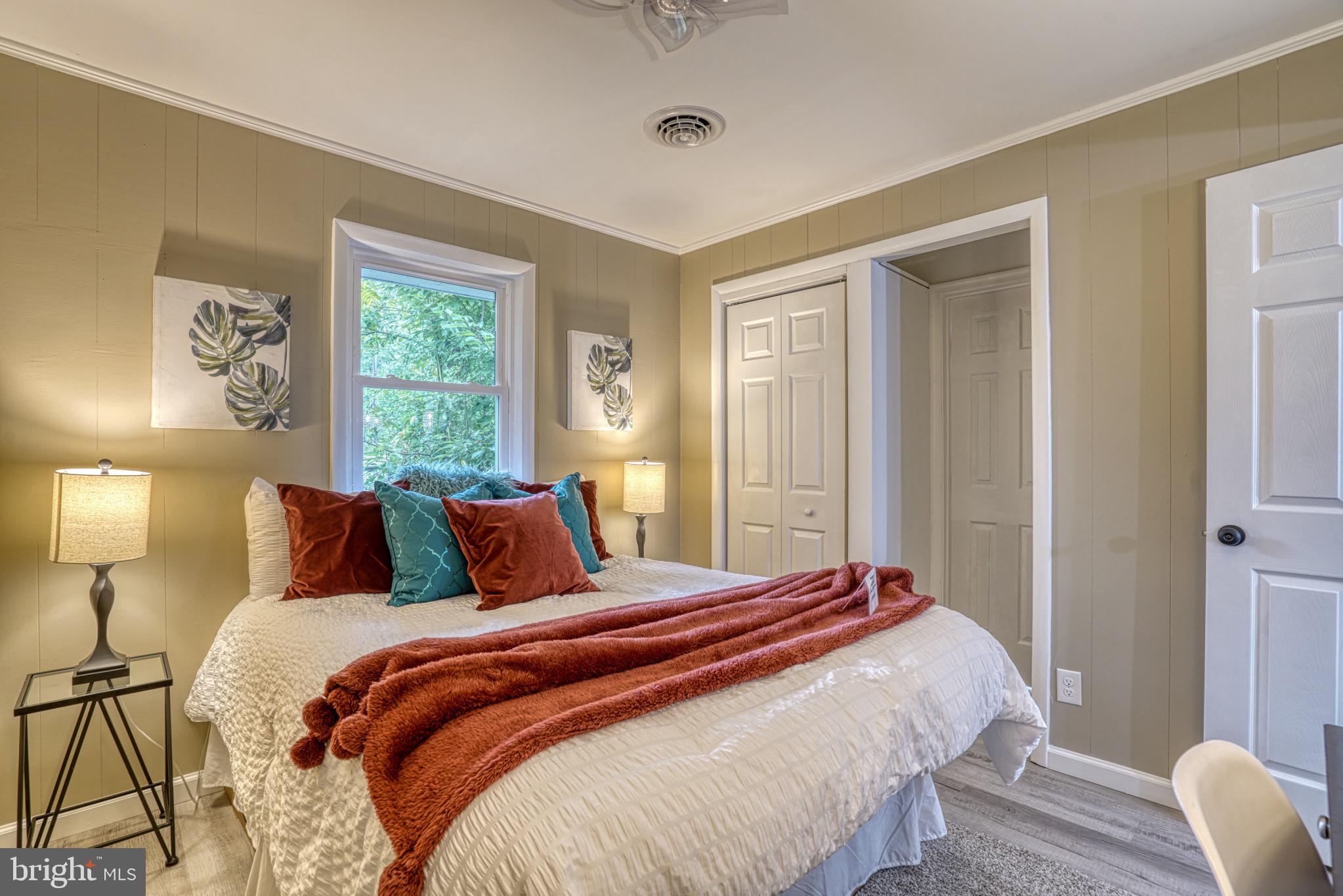 18 Oak Street Cambridge, MD 21613 - Photo 15 of 43 a bedroom with a bed and a lamp next to a window