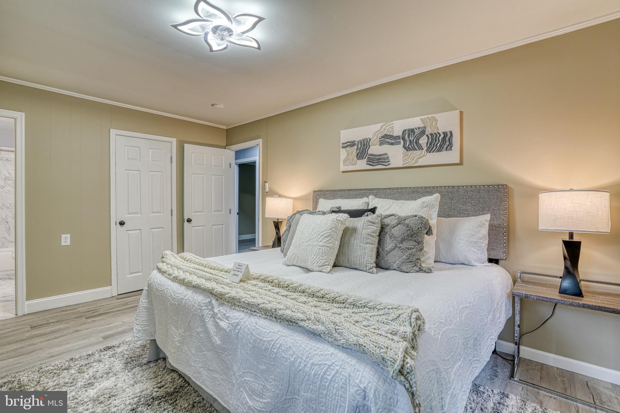 18 Oak Street Cambridge, MD 21613 - Photo 23 of 43 a spacious bedroom with a bed and a chandelier