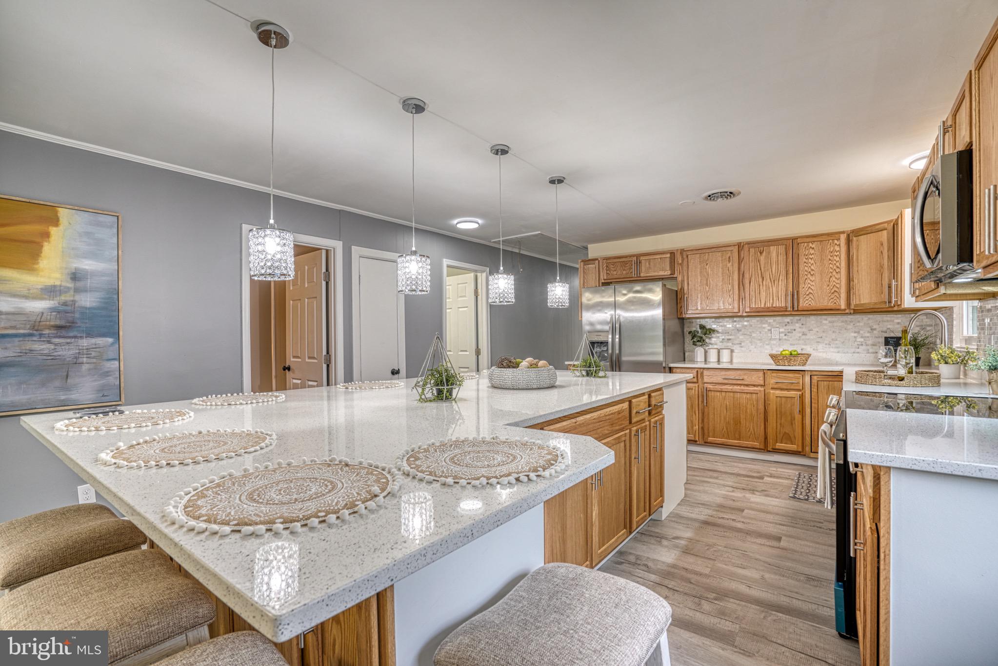 18 Oak Street Cambridge, MD 21613 - Photo 9 of 43 a large kitchen with kitchen island a sink a stove a center island a stove and cabinets