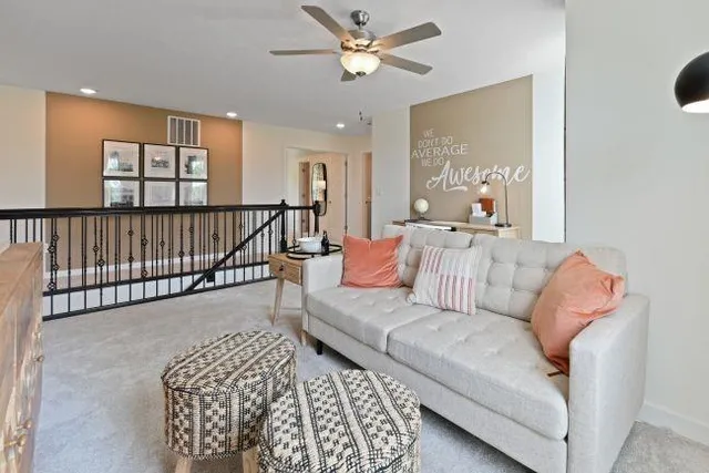 a living room with furniture ceiling fan and a window