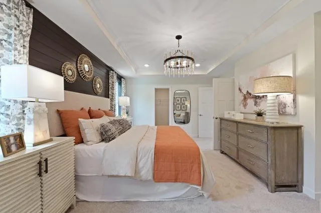 a bedroom with a large bed and a chandelier