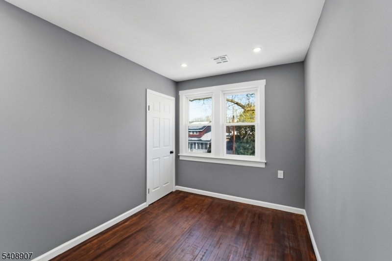 209 Vine Street Delanco, NJ 08075 - Photo 18 of 43 a view of an empty room with wooden floor and a window