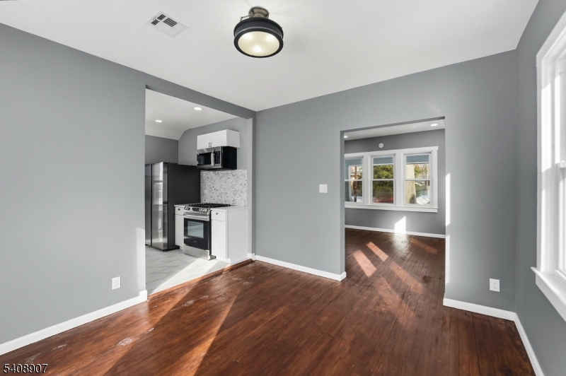 209 Vine Street Delanco, NJ 08075 - Photo 9 of 43 an empty room with wooden floor kitchen view and windows